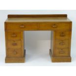 An early / mid 20thC Cotswold school double pedestal desk comprising two long drawers above two