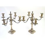 A pair of early 20thC silver plate four-branch table candelabrum / candelabra with central sconce