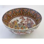 A large Japanese bowl with hand painted decoration the central roundel depicting figures / geisha