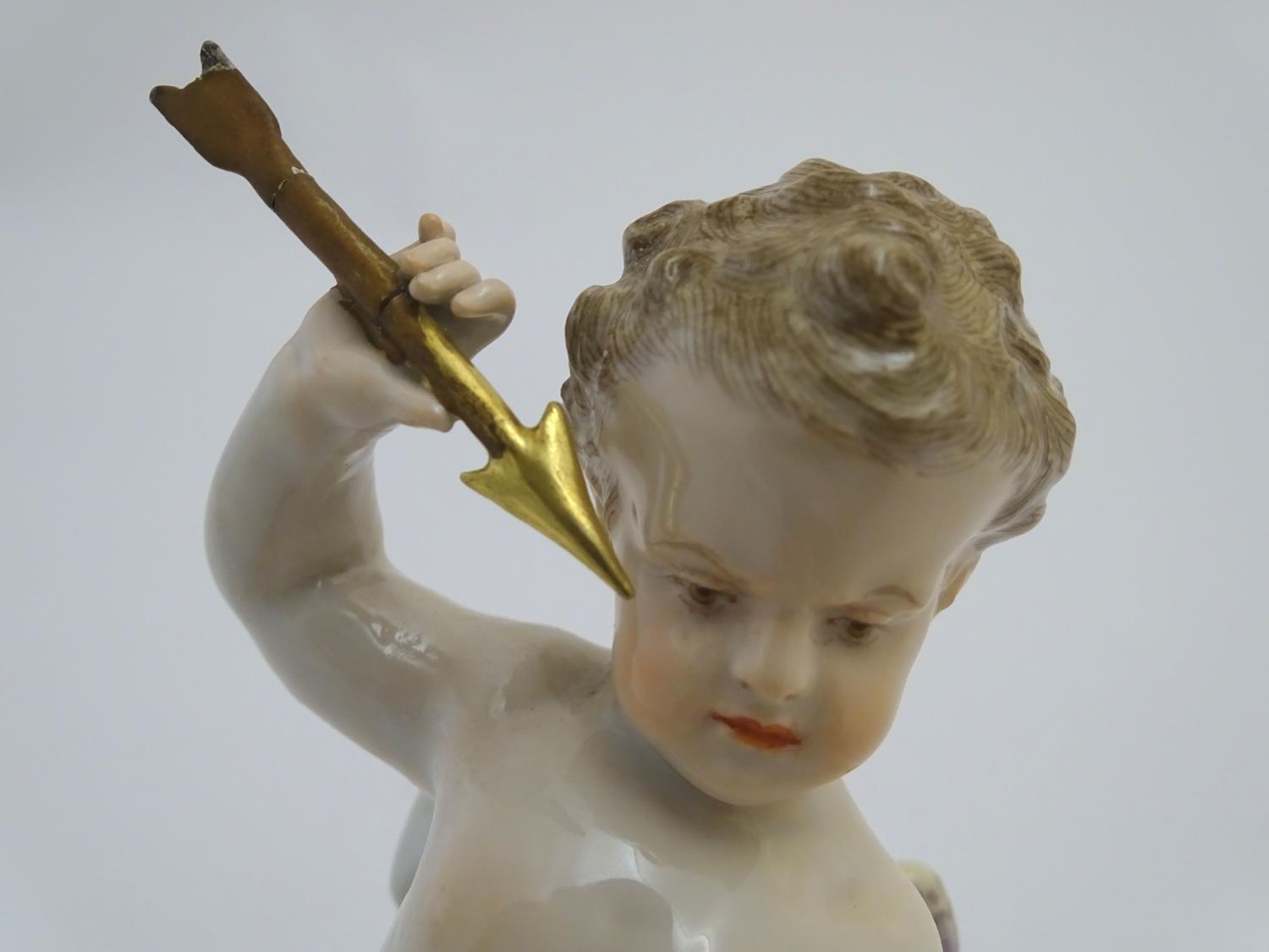 A late 19thC Meissen figure of Cupid holding an arrow and a flaming heart. On a naturalistic base. - Image 6 of 9