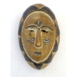 Ethnographic / Native / Tribal: A carved and painted figural mask with geometric detailing.