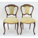 A pair of mid / late 19thC walnut boudoir chairs, having a carved top rail and mid rail with an