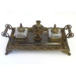 A 19thC cast brass standish / inkwell of rectangular form with twin scrolling handles and floral and