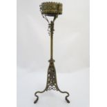 A late 19thC brass table lamp stand, of tripod form, ornately decorated with floral and scrolling