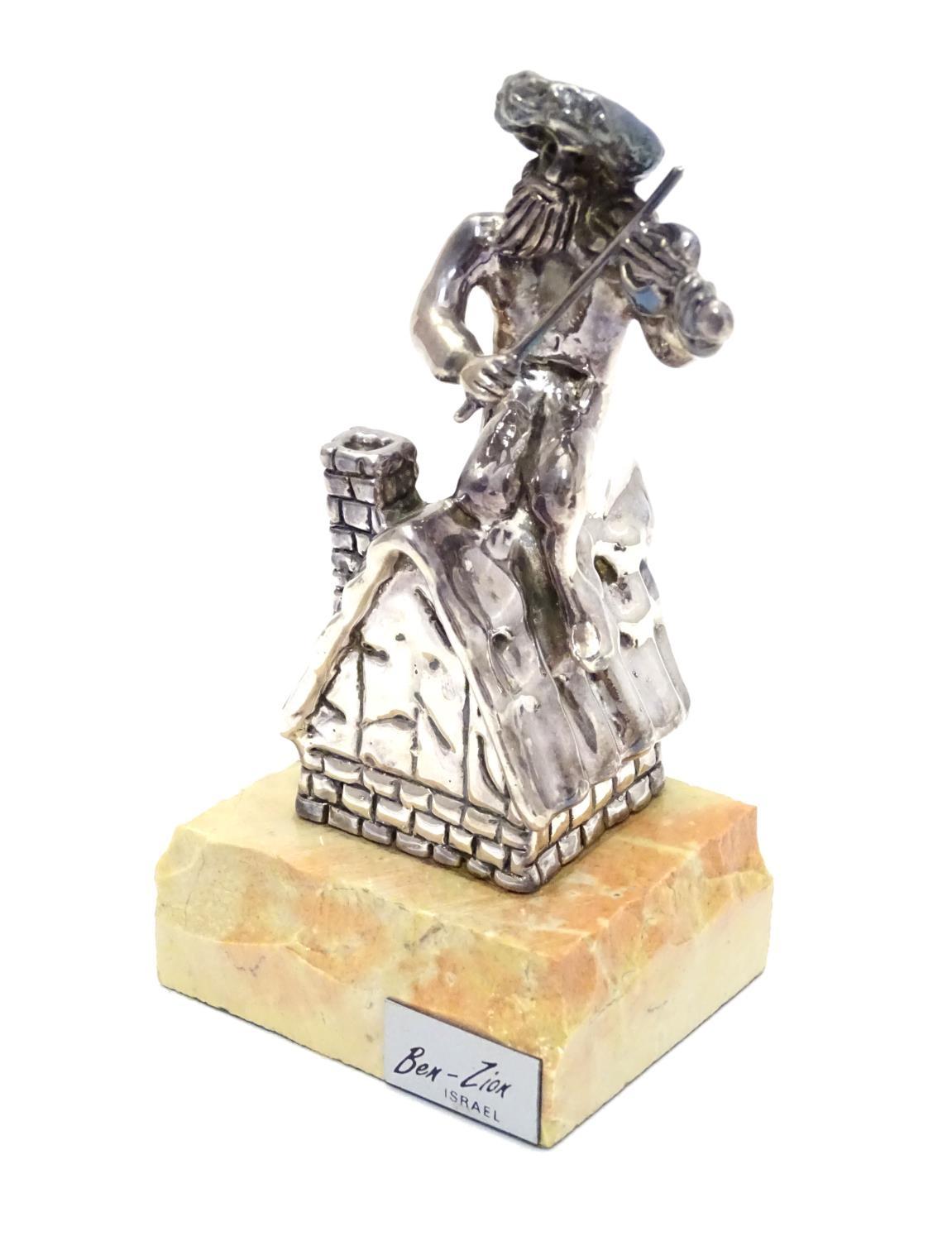 A 925 silver model of a fiddler on a roof mounted on a marble base. Base bears a plaque entitled ?