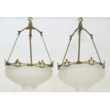 A pair of W.A.S. Benson Arts and Crafts brass and frosted glass pendant lights the moulded and