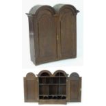 An early / mid 18thC mahogany bookcase with a double domed pediment above two panelled doors. 40"