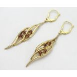 A pair of 9ct gold drop earrings of leaf form, each set with four garnet coloured stones. Approx.