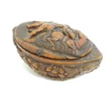 A Continental carved nut snuff box, the hinged lid decorated with a horse and a man carrying a