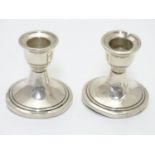 A pair of silver candlesticks hallmarked Birmingham 1962 maker Sanders & Mackenzie 2 1/2'' high