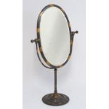 A mid / late 20thC coppered dressing mirror, with a tilting oval surround and a bevelled glass