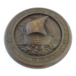 A carved wooden roundel depicting a nautical scene with sailing boat at sea in high relief, the