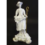 A Royal Crown Derby white glazed female figure modelled as a shepherdess, with a crook and holding