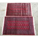 Carpet / Rug : Two red ground rugs with geometric borders and central medalion bands. 60" x 38"