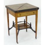 A late 19thC / early 20thC envelope card table with marquetry detailing, opening to show dished