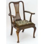 A 19thC open armchair with a Chippendale style backrest, swept arms and having a drop in seat. The