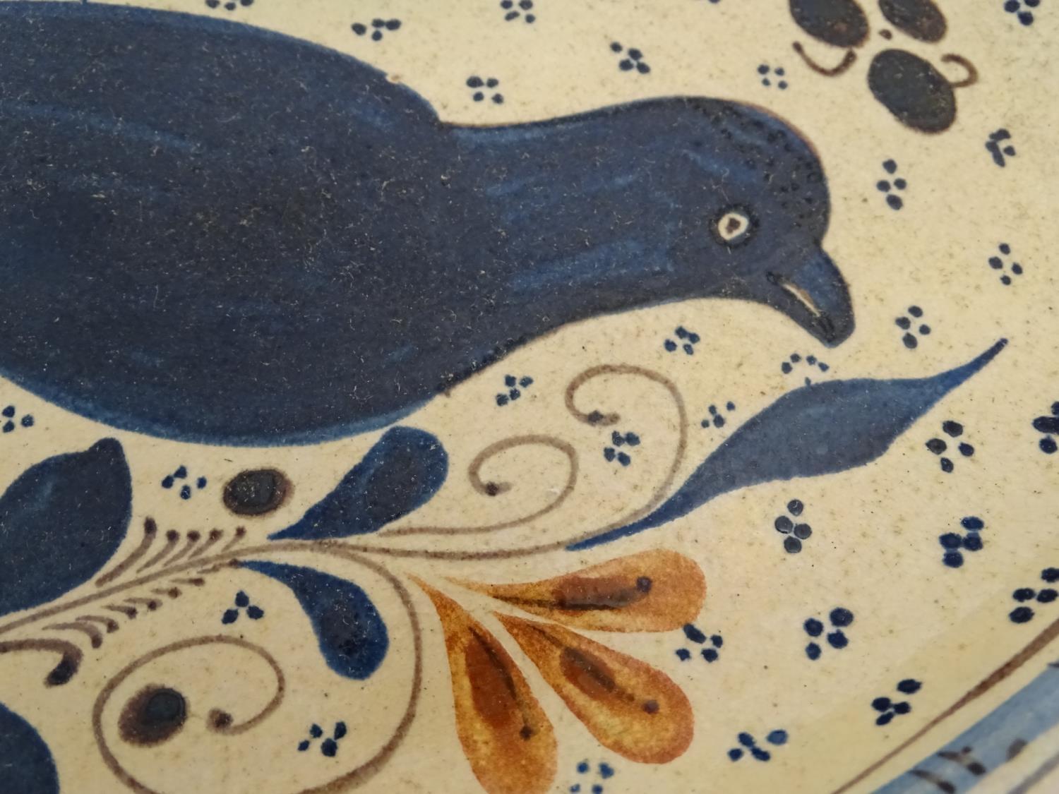 A Swiss terracotta oval pottery dish with hand painted folk art decoration depicting a bird - Image 5 of 6