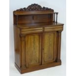 A mid 19thC mahogany chiffonier with a carved upstand above a single shelf raised on barley twist