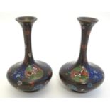 A pair of early 20thC cloisonne bottle vases with elongated necks and flared rims, with floral