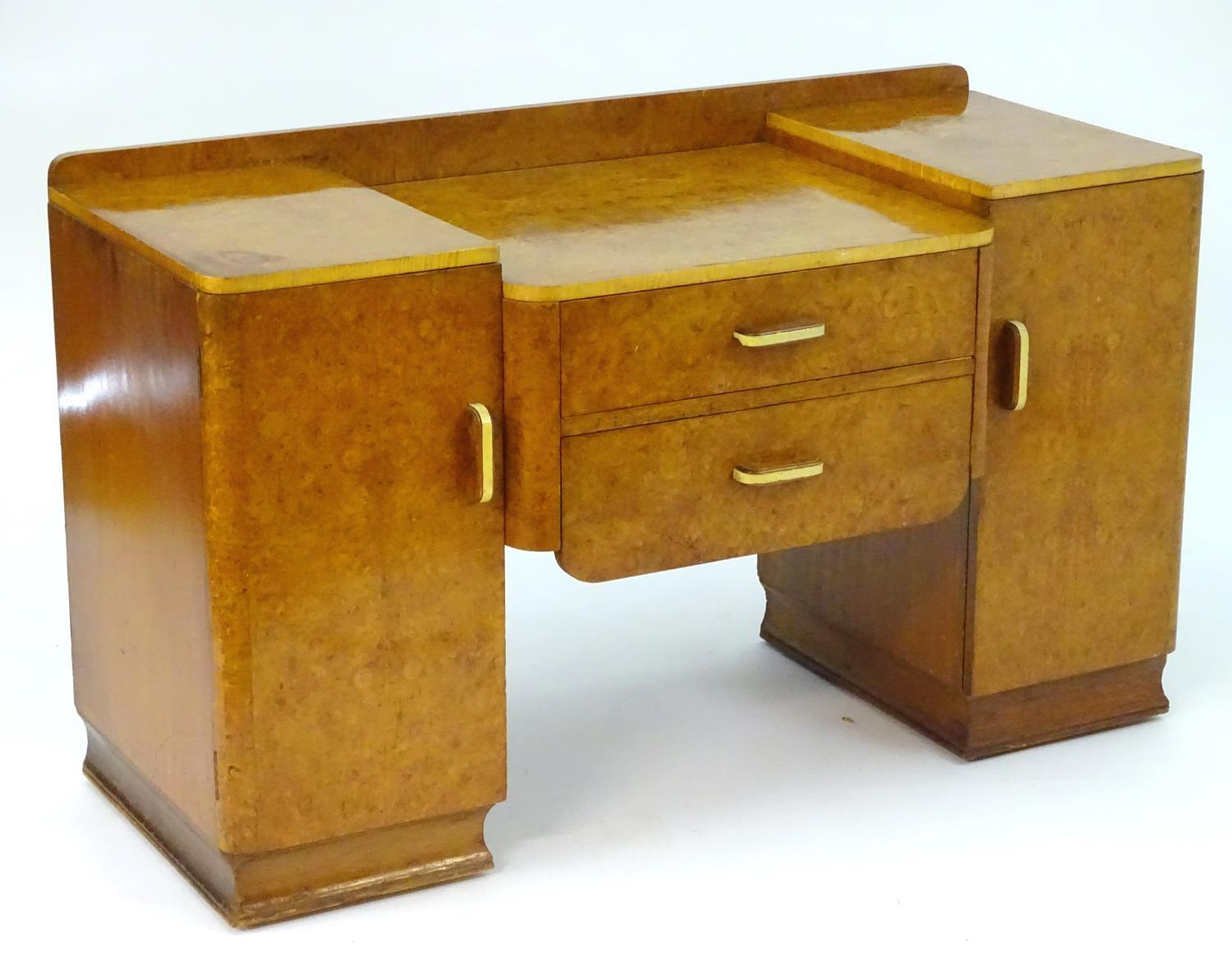 A mid 20thC burr walnut dressing table with two short drawers flanked by cupboards to each side. 48"