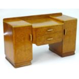 A mid 20thC burr walnut dressing table with two short drawers flanked by cupboards to each side. 48"
