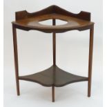 An early 20thC mahogany washstand on squared legs and having a shaped under tier. 31" wide x 22"