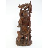 A 20thC carved Oriental figural group depicting an elder with a pipe and a bamboo staff, and a child