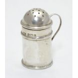 A silver pepperette formed as a flour shaker with loop handle. Hallmarked Birmingham 1902 maker