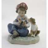 A Lladro figure of a boy with a dog pulling flower petals, I Hope She Does, model no. 5450. Marked