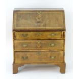 A 20thC walnut bureau with a fall front above three long graduated drawers with brass handles and