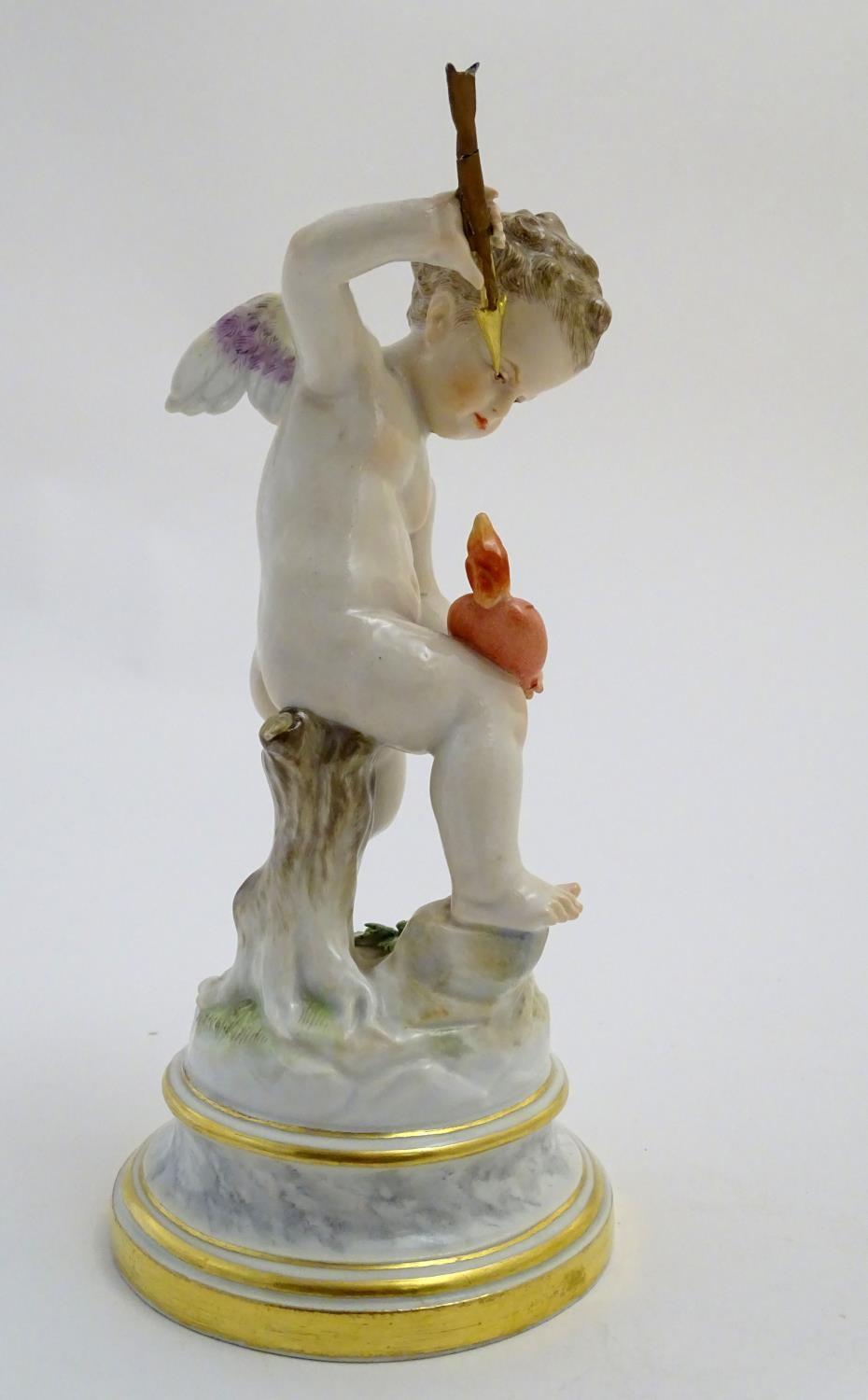 A late 19thC Meissen figure of Cupid holding an arrow and a flaming heart. On a naturalistic base. - Image 4 of 9