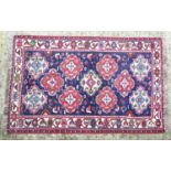 Carpet / Rug : A rug with blue ground and cream ground border, decorated with geometric vignettes
