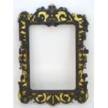 An early 20thC ebonised mirror frame with gilt highlights and foliate carvings. 61? high x 42?