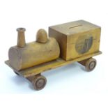 A Mauchline ware money box formed as a train with a vignette depicting Beachy Head Lighthouse.