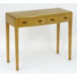 A mid 20thC Cotswold school side table in the manner of Edward Barnsley, having shaped handles and