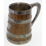 An early 20thC coopered tankard, constructed of oak with silver plated bands, interior and handle. 5