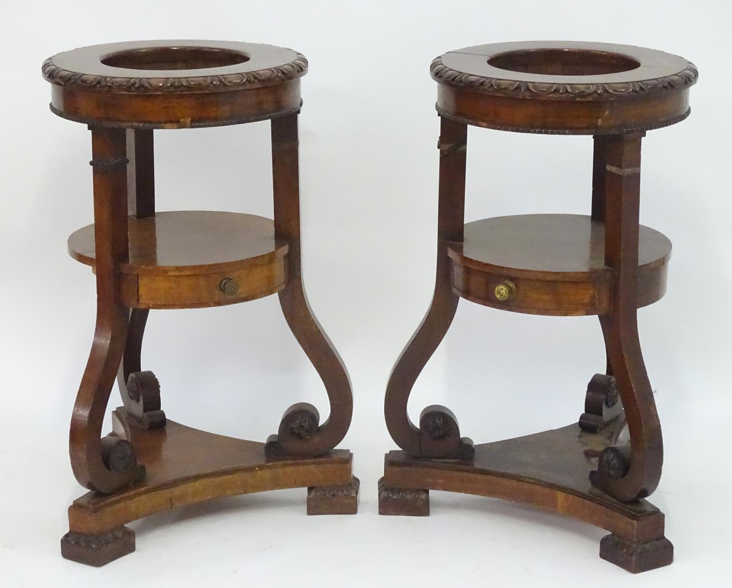 A pair of mahogany jardiniere stands with egg and dart moulded decoration, scrolled supports and