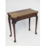 A George II mahogany games / card table with castellated top edges and opening using a concertina