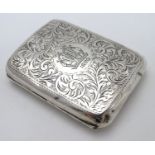 A silver cigarette case of shaped form with engraved acanthus scroll decoration. Hallmarked