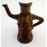A treacle glazed Toby jug teapot formed as a seated man, his arms forming the handle and spout.