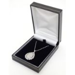 A 9ct white gold pendant set with a profusion of diamonds, on an 18" long and. The pendant approx 1"