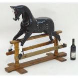 A 19thC carved wooden rocking horse with hand painted detail, mounted on a trestle base. Approx.