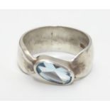 A silver ring set with single oval light blue coloured stone. Rings size approx O Please Note - we