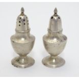 A pair of silver salt and pepper pots . Marked Sterling Hong Kong. Approx 2" high (2) Please