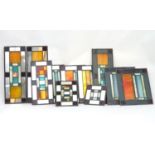 A suite of eleven Art Deco geometric stained glass window panes of various sizes, with slag glass