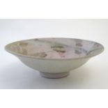 A studio pottery bowl with Oriental inspired decoration depicting stylised lilies and lily pads with