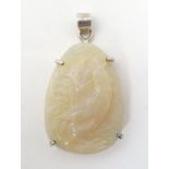 An Oriental carved jade pendant with cockerel decoration in a silver mount. Approx 2" long Please