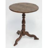 A 19thC occasional table with a planked top above a turned oak pedestal base with three shaped legs.