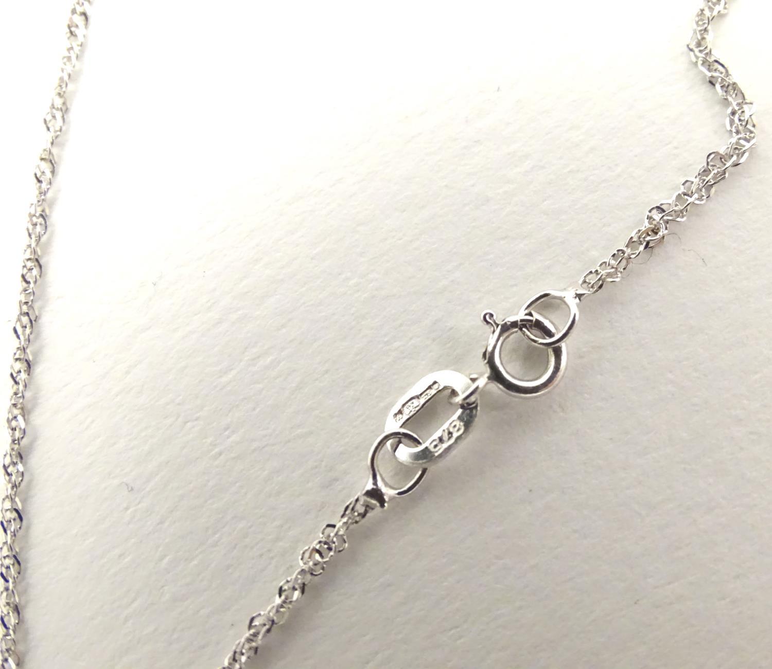 A 9ct white gold pendant set with a profusion of diamonds, on an 18" long and. The pendant approx 1" - Image 2 of 7