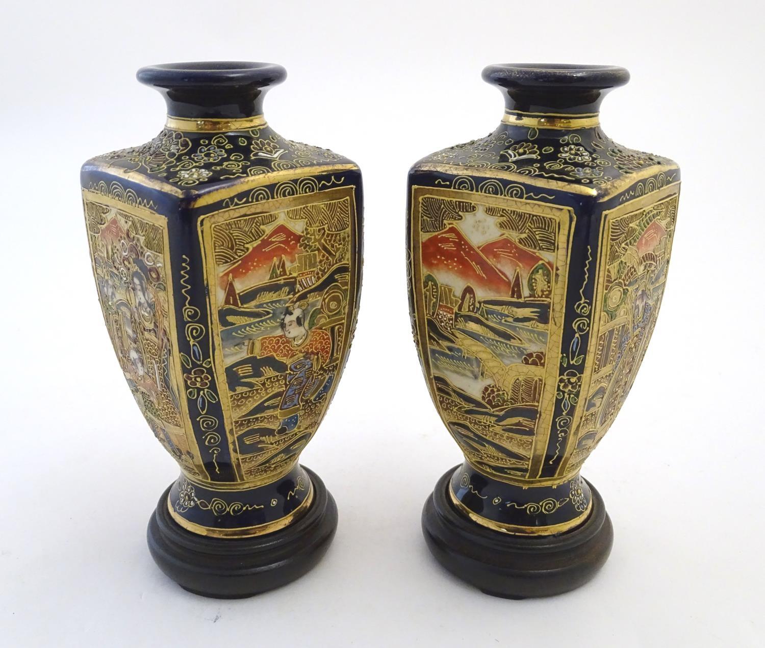 A pair of Japanese Satsuma vases of square baluster form with a cobalt blue ground, with panelled